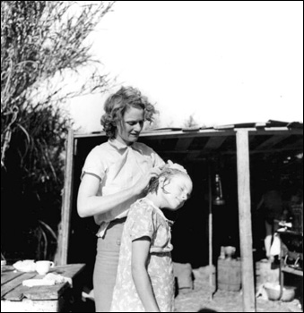 Migrant worker cleaning her daughter's scalp: Belle Glade, Florida (1939)