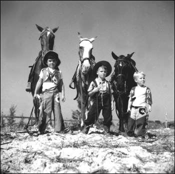 Three boys dressed as a cowboys with their horses: Saint Petersburg, Florida (1947)