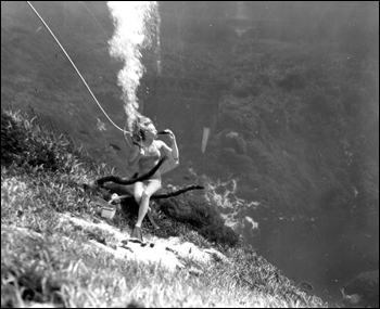 Unidentified woman drinking a coke underwater during performance as mermaid at Weeki Wachee Springs (1950)