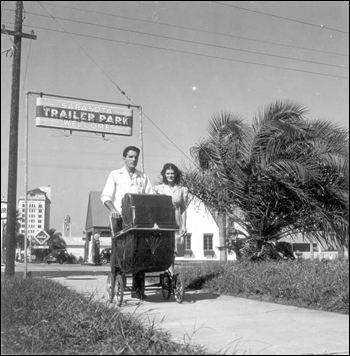 Al and Roey Stickles pushing a baby stroller through a trailer park in Sarasota, Florida (1946)