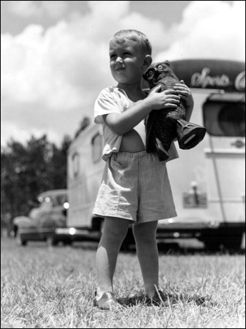 Michael Sadler holding a sculpture stands outside a trailer: Dead Lakes, Florida (1947)