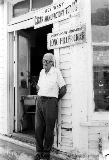 Rex Shaw standing in front of his factory on Fleming Street: Key West, Florida (197-)