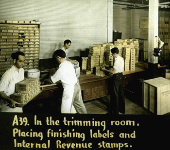 In the trimming room, placing finishing labels and Internal Revenue stamps (192-)