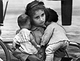 Young Cuban refugee holding her dolls in airport (1961)