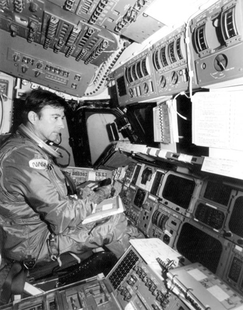 Astronaut John W. Young conducting a pre-flight check on the Space Shuttle Columbia (1980)