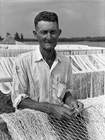 Commercial fisherman Elisha "Pappy" Turner working on his seine net in Naples, Florida (1949)