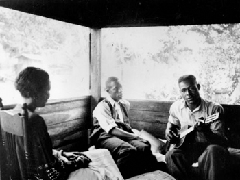 Gabriel Brown playing guitar as Rochelle French and Zora Neale Hurston listen: Eatonville, Florida (1935)