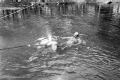 Diver and creature character in the water during filming of "Revenge of the Creature" movie.