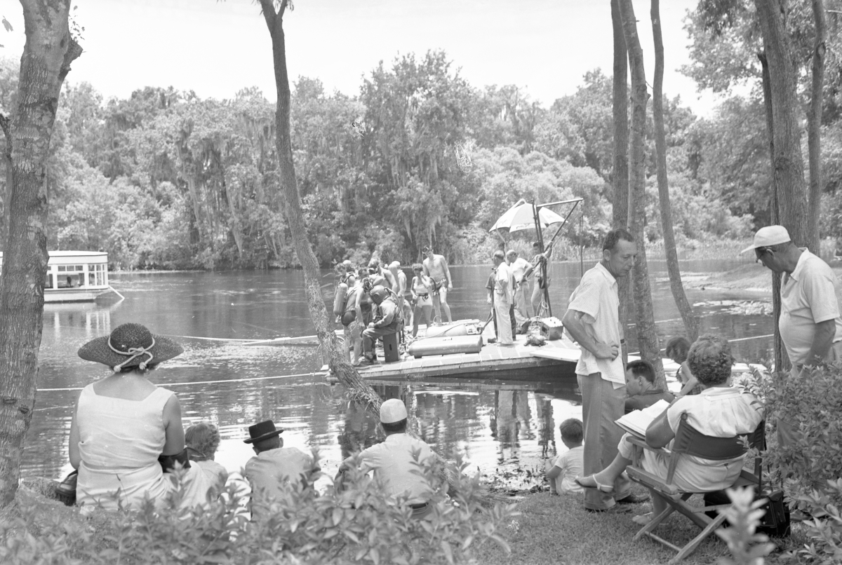 Spectators watching crew work on floating platform during filming of the "Revenge of the Creature" movie at Silver Springs.