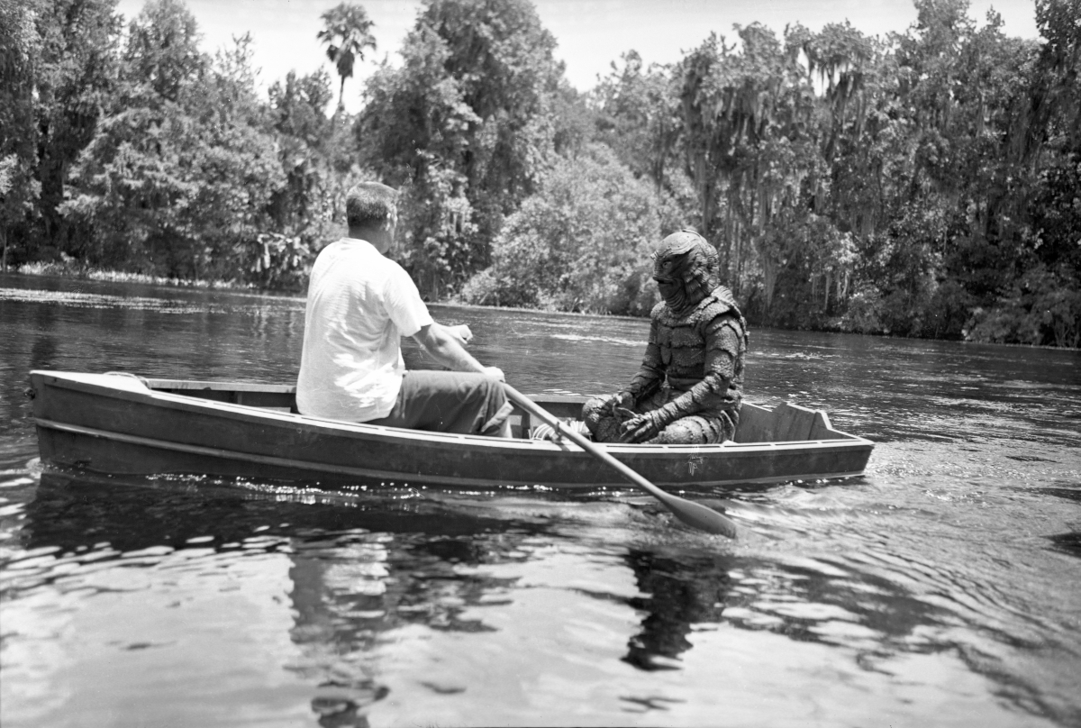 A crew member in a rowboat with Ricou Browning as Gill Man during filming of Revenge of the Creature at Silver Springs, 1954. Photo by Bruce Mozert.