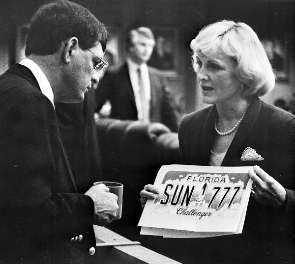 Rep. Fran Carlton (D-Orlando) lobbying Rep. Dale Patchett (R-Vero Beach) to pass the Space Shuttle Challenger license plate bill. The bill did not pass until 1999, when it became the first of Florida's specialty plates.