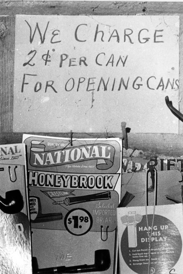 Sign explaining a two-cent charge for opening cans at a general store in Two Egg (circa 1970).