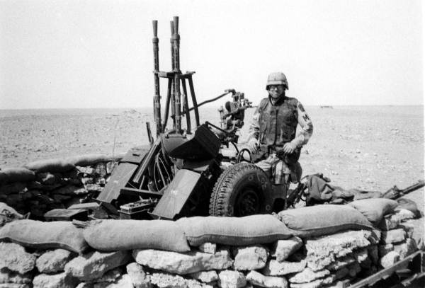 First Lieutenant Robert Bruce Graetz standing beside a destroyed Iraqi anti-aircraft gun approximately 30 miles inside southern Iraq.