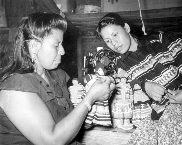 Annie Tiger Bowers showing Lawanna Osceola Niles how to sew a costume doll (1958)