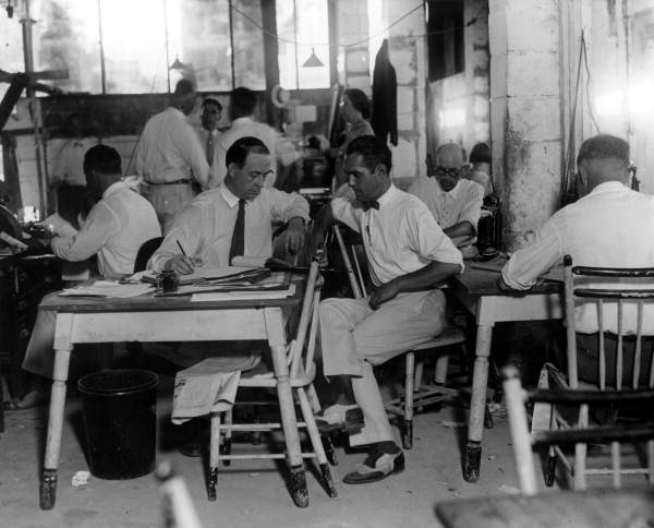 Real estate men working quickly in a Boca Raton office. When the Mizner Development Corporation first opened up Boca Raton for sale, his agents often worked late into the night processing paperwork for the sales (1925).