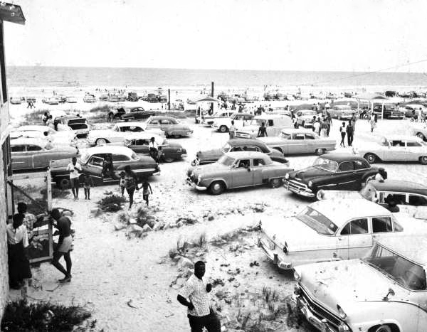 Cars pack the parking area at Butler Beach, as visitors enjoy a sunny day on Florida's Atlantic coast (circa 1950s).