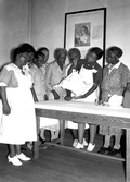 Public Health nurse showing midwives how to use a portable scale - Leon County, Florida