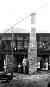 C.B. Harrison and son in front of government plan still supervised by C. H. Coulter