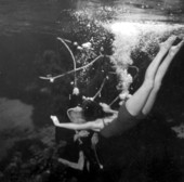 Santa (Newt Perry) gets a big hug from grateful mermaid who has received a brand new pair of paddle fins for Christmas - Weeki Wachee, Florida.