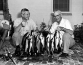 Governor LeRoy Collins helping his father hold up their catch of black bass - Tallahassee, Florida.