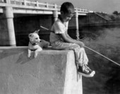 Young boy fishing with his dog - Palm Beach County, Florida.