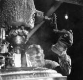 A Newport Industries worker filling a drum with rosin in a plant - Pensacola, Florida.