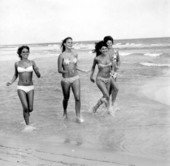 Four bikini clad women frolicking on the beach - Pensacola, Florida.