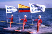 View showing water skiers holding flags during performance at the Cypress Gardens theme park in Winter Haven, Florida.