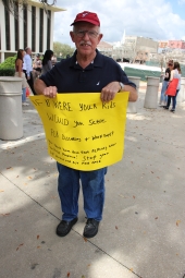 Gun-control activist Claude Kenneson holding up his sign at the Never Again Rally in Tallahassee.