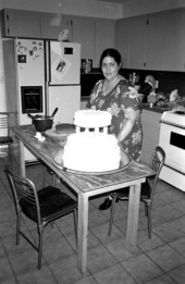 Ana Paz decorating a wedding cake in the kitchen of her home - Miami, Florida