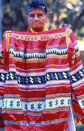 Lottie Shore holding up an example of Seminole clothing.