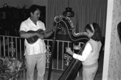 Jesus Rodriguez playing cuatro while apprentice Ana Maria de Armas plays Venezuelan harp- Miami, Florida.