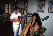 Jesus Rodriguez playing cuatro while apprentice Cecilia Santos plays Venezuelan harp- Miami, Florida.