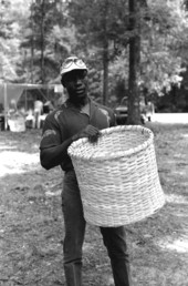 Alfonso Jennings at the 1983 Florida Folk Festival holding a basket he made - White Springs, Florida