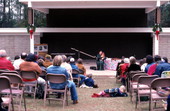 Jean Ritchie playing an autoharp while the crowd listens - White Springs, Florida