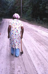 Lucreaty Clark carrying her ax in search of white oak to make baskets