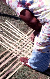 Basket maker Lucreaty Clark laying out strips of white oak