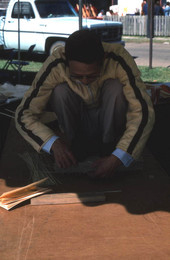 Tuyen Pham tying together pieces of whittled wood - Pensacola, Florida.