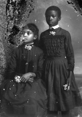 Two girls wearing dark dresses.