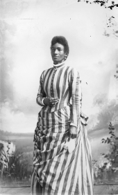 Woman in striped dress holding handkerchief.