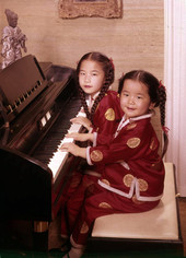 7-year-old Chinese prodigy Virginia "Ginny" Tiu at the piano with her 5-year-old sister Elizabeth.