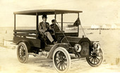 Portrait of an unidentified man sitting in a truck by the water.