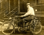 Portrait of an unidentified man sitting on a Harley Davidson Model 7A motorcycle.