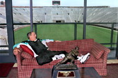 Florida State University head football coach Bobby Bowden relaxing at Doak Campbell Stadium with the Heisman trophy awarded to Charlie Ward in 1993.