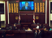 President George W. Bush is shown on the House floor presentation screen, top, as he outlines in a video his vision for future U.S. space missions Thursday, April 14, 2005..