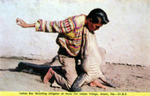 Indian boy wrestling alligator at Musa Isle Indian village - Miami, Florida