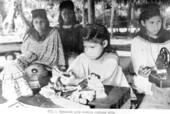 Seminole girls making costume dolls.