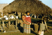 Seminole Indian mother and child by chickee hut at the Dania Seminole Indian Reservation