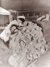 Boys sleep in the fish house on the idle nets..