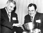 Two football coaches struggle to grasp a trophy - Tallahassee, Florida.